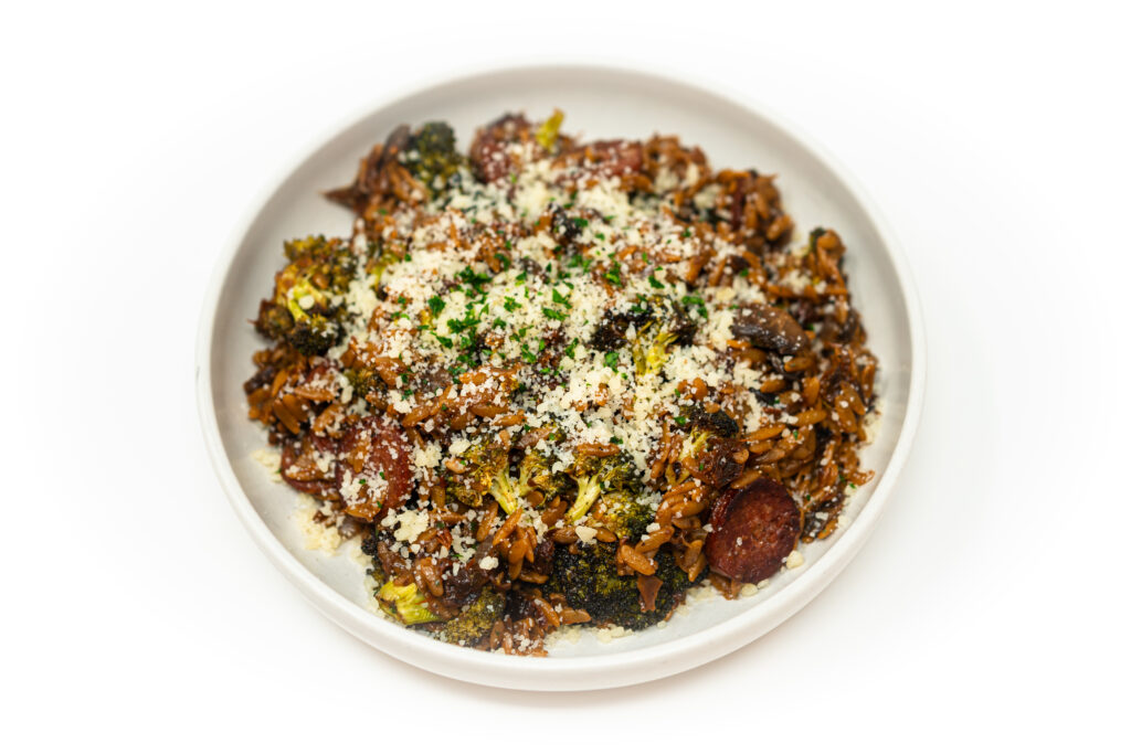 Sun-Dried Tomato and Smoked Sausage Orzo Skillet served in a pan, featuring tender orzo cooked with savory smoked sausage, tangy sun-dried tomatoes, and fresh herbs, creating a hearty and flavorful one-pan meal.