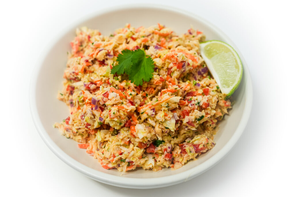 Creamy Papaya Coleslaw served in a bowl, featuring shredded cabbage and carrots tossed in a rich, creamy dressing with sweet, tropical papaya for a refreshing and flavorful twist on the classic coleslaw.