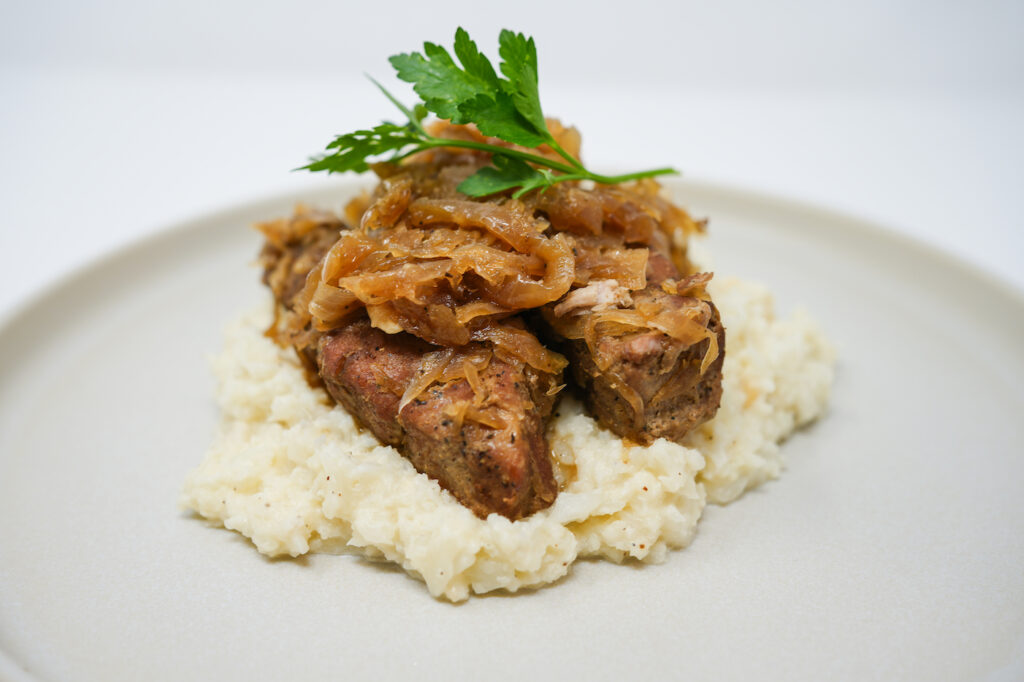 Beer Braised Country-Style Ribs and Sauerkraut served on a plate, featuring tender, slow-cooked ribs braised in beer with tangy sauerkraut, garnished with fresh herbs for a hearty, comforting meal