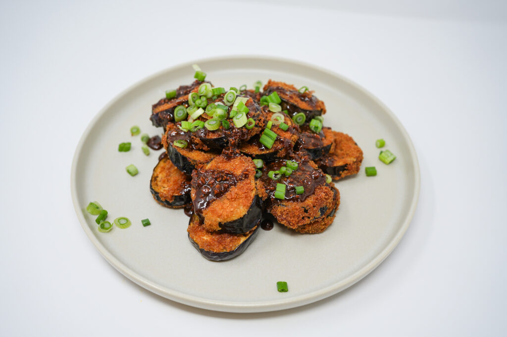 Honey Garlic Glazed Fried Indian Eggplant served on a plate, featuring crispy fried eggplant slices coated in a sticky, sweet honey garlic glaze, offering a perfect balance of savory and sweet flavors with a tender texture