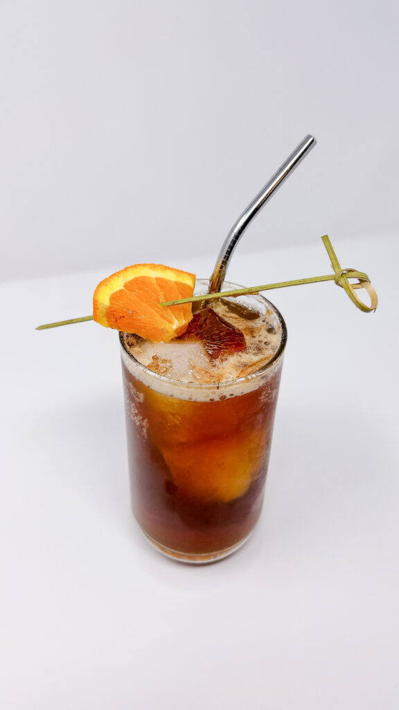 Coffee-Infused Vodka Tonic served in a glass, featuring a smooth blend of coffee-infused vodka topped with tonic water, and garnished with an orange slice for a refreshing and citrusy twist on a bold cocktail