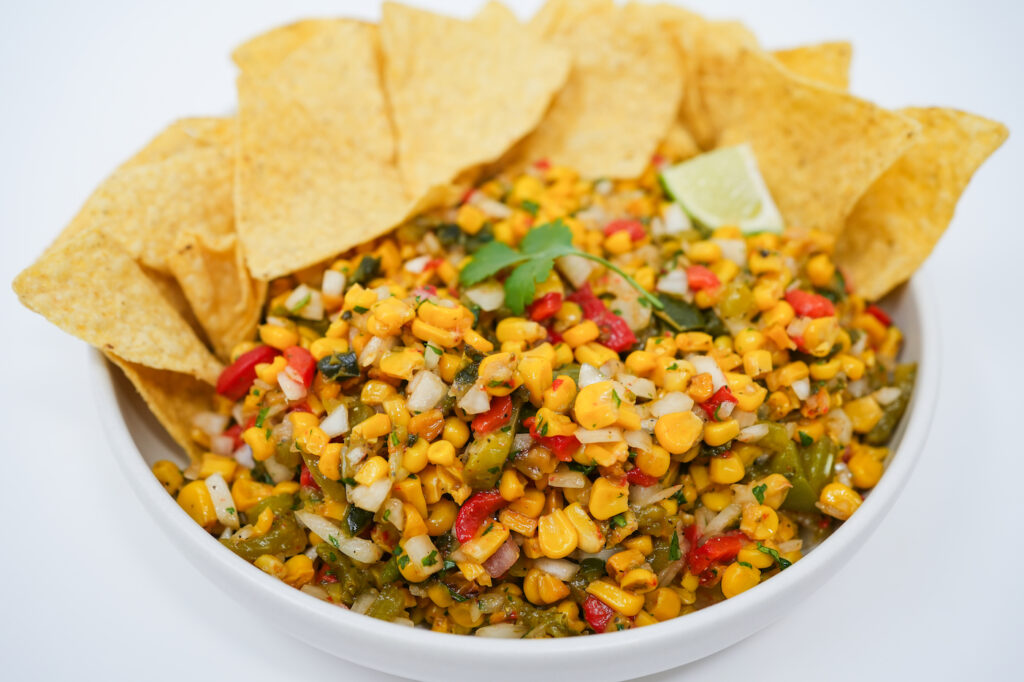 Roasted Corn and Pepper Medley Salsa served in a bowl, showcasing a colorful mix of roasted corn, vibrant peppers, and fresh herbs, creating a bright and flavorful salsa
