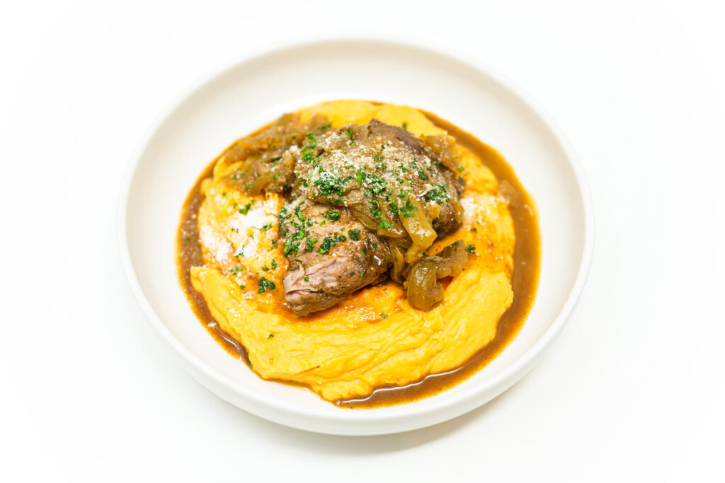 Whiskey braising pork tenderloin served over creamy mashed sweet potatoes, topped with caramelized apples and onions.
