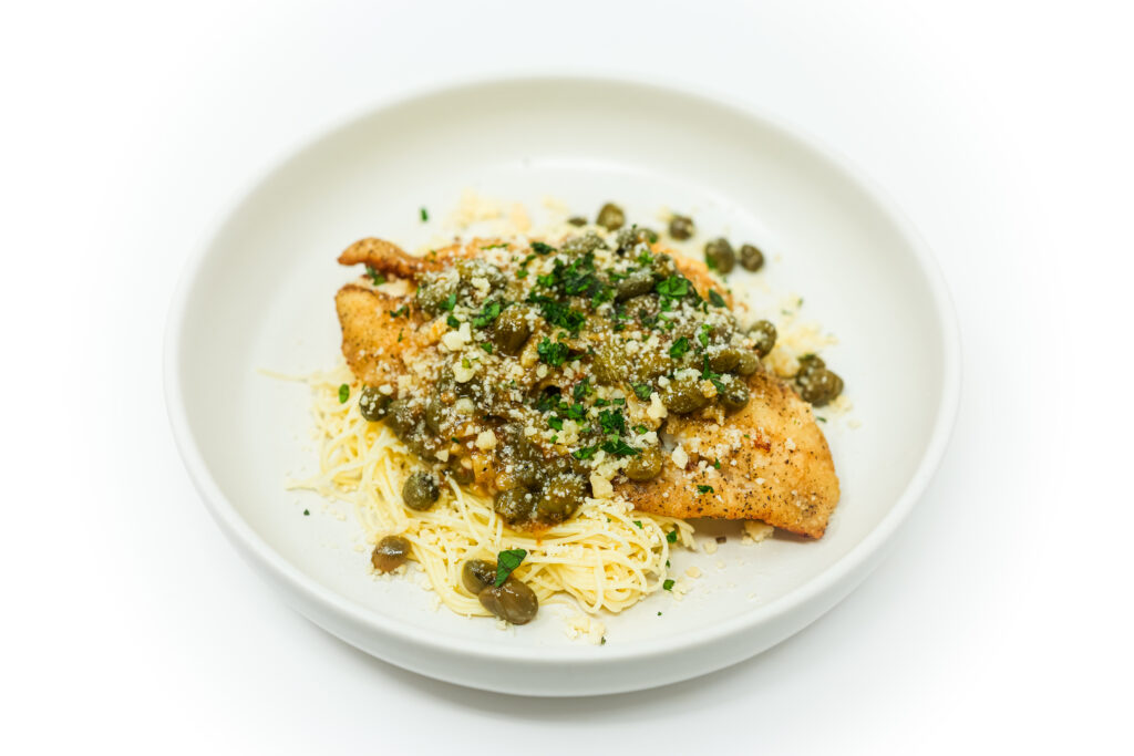 Flounder Piccata served on a plate, featuring tender flounder fillets in a bright, tangy lemon-butter sauce with capers and fresh parsley.