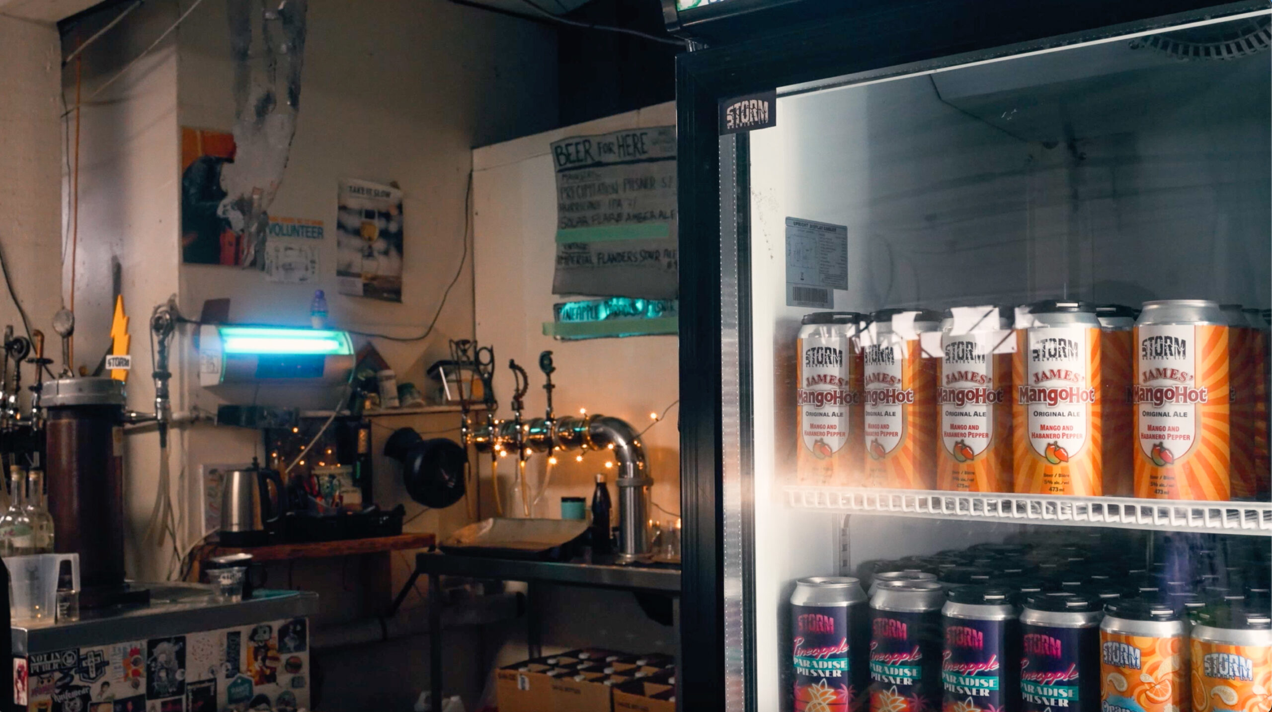 Fridge stocked with craft beer cans and beer taps at Storm Brewing’s gritty, garage-like space in Vancouver.