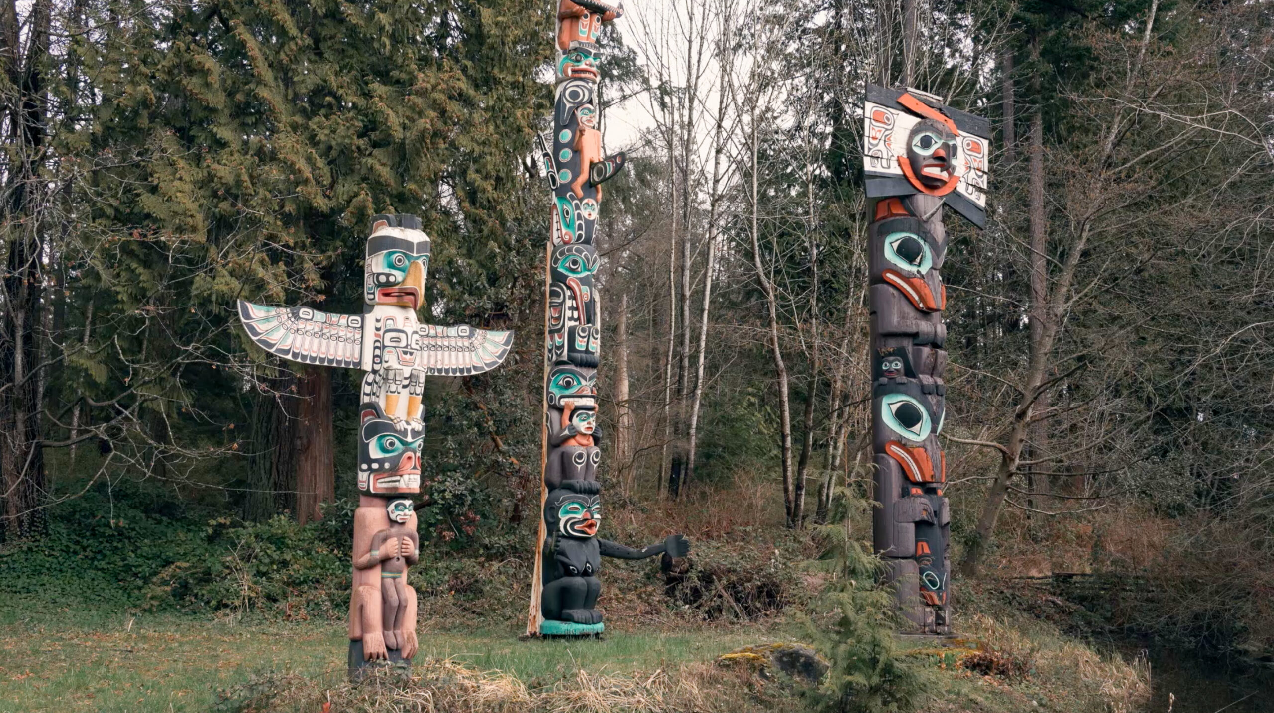 Totem poles surrounded by trees in Stanley Park.