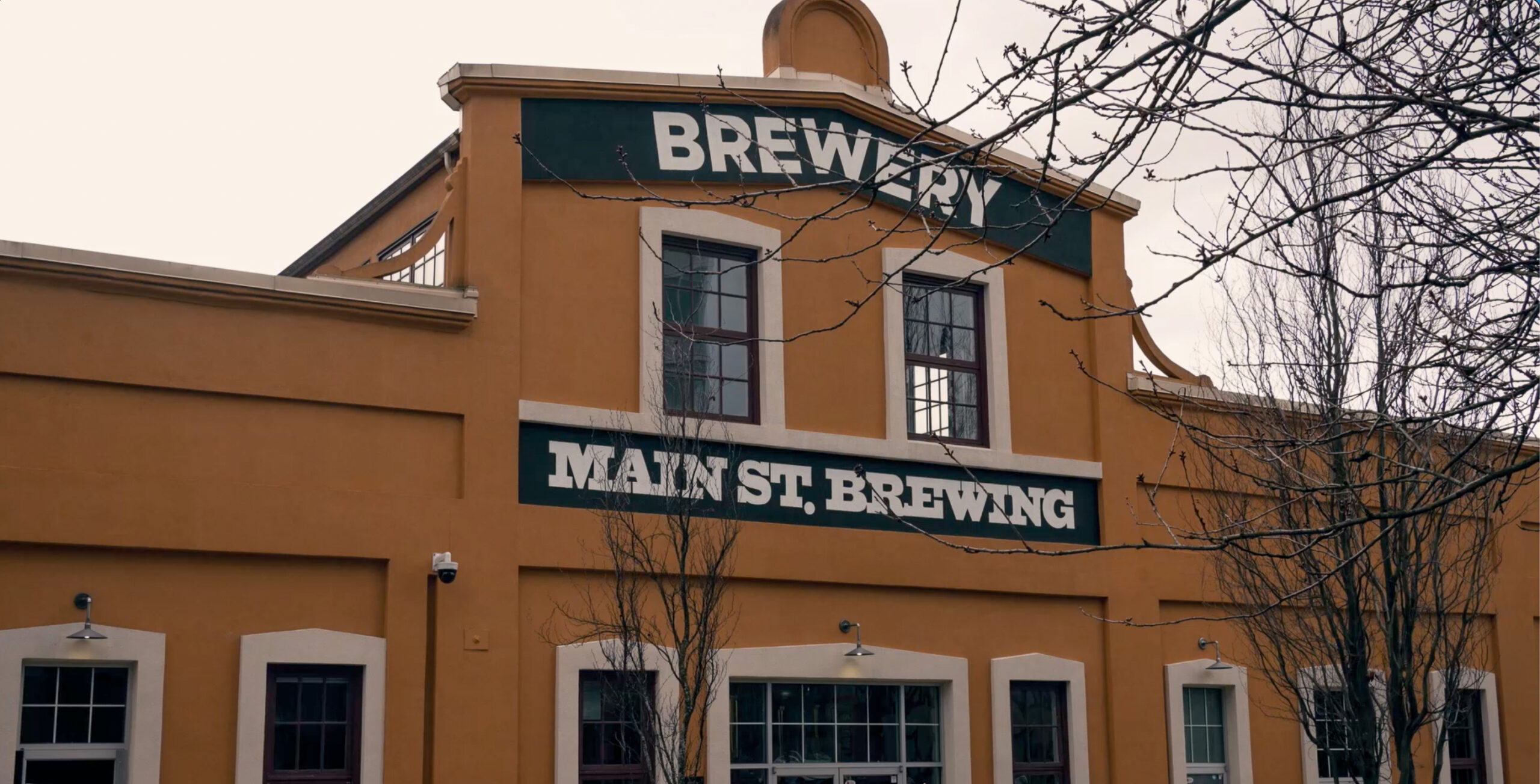 Facade of Main St. Brewing, with bold green-and-white signage.