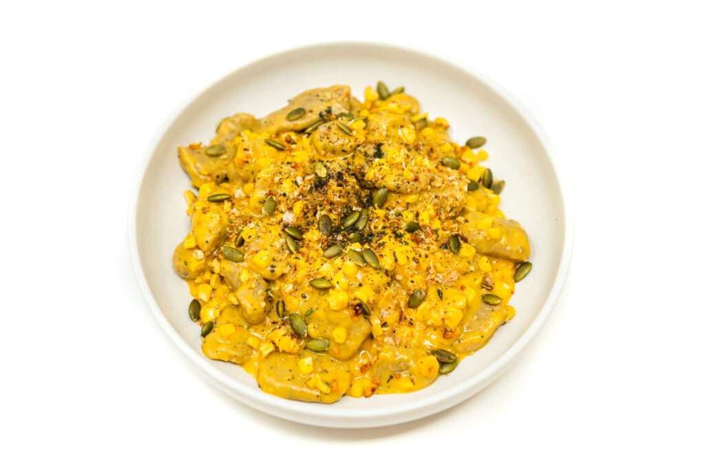 Butternut squash gnocchi with masa harina tossed in brown butter sauce, topped with charred corn kernels, toasted pepitas, breadcrumbs, and chili powder.