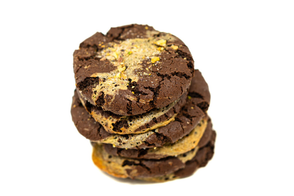 Close-up of chocolate pistachio swirl cookies showing marbled layers of dark cocoa dough and vibrant green pistachio paste.