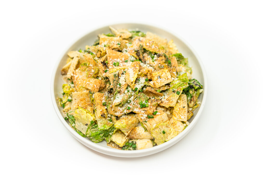 Charred Caesar salad with broiled romaine hearts and endive, topped with toasted breadcrumbs and real anchovy-infused dressing.