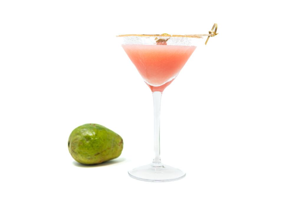 Pink Guava Margatini cocktail in a chilled martini glass, garnished with a lime wheel and green olive, served on a clean modern surface.