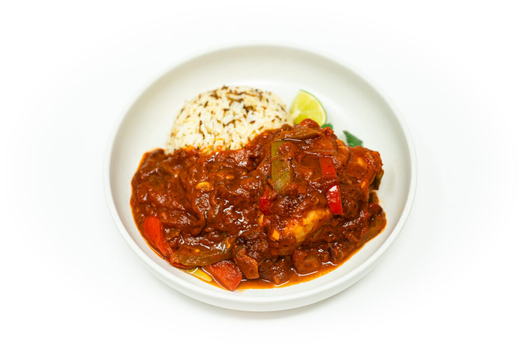 Kingklip Veracruz with smoky chipotle-tomato sauce, olives, capers, pepitas, and cumin rice, garnished with cilantro and lime.