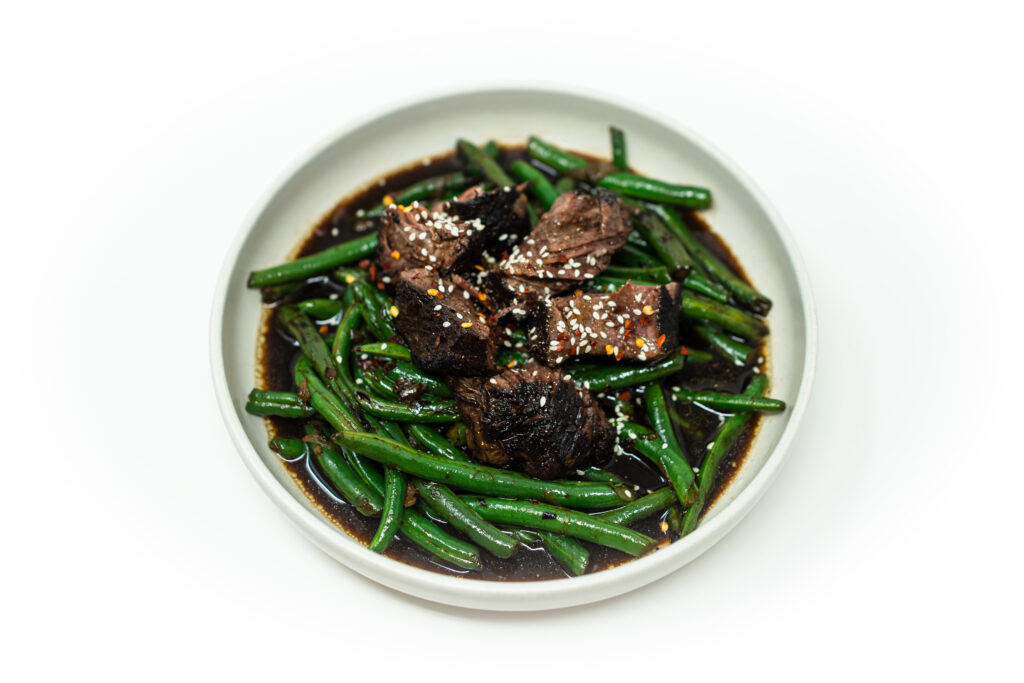Shredded braised beef short rib glazed in aromatic sauce, piled over wok-charred green beans with shallots, garlic, and ginger.