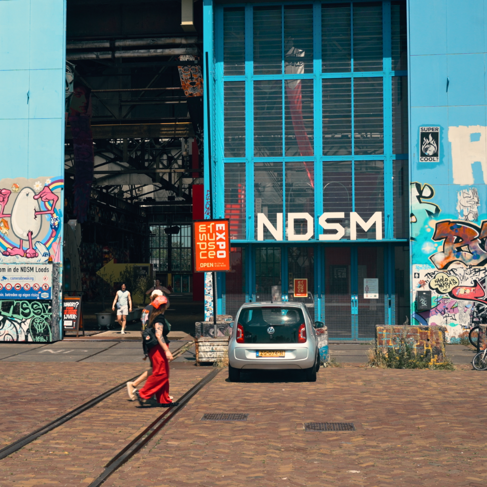 Street view of NDSM wharf in Amsterdam, with colorful graffiti and industrial buildings turned into cultural spaces.