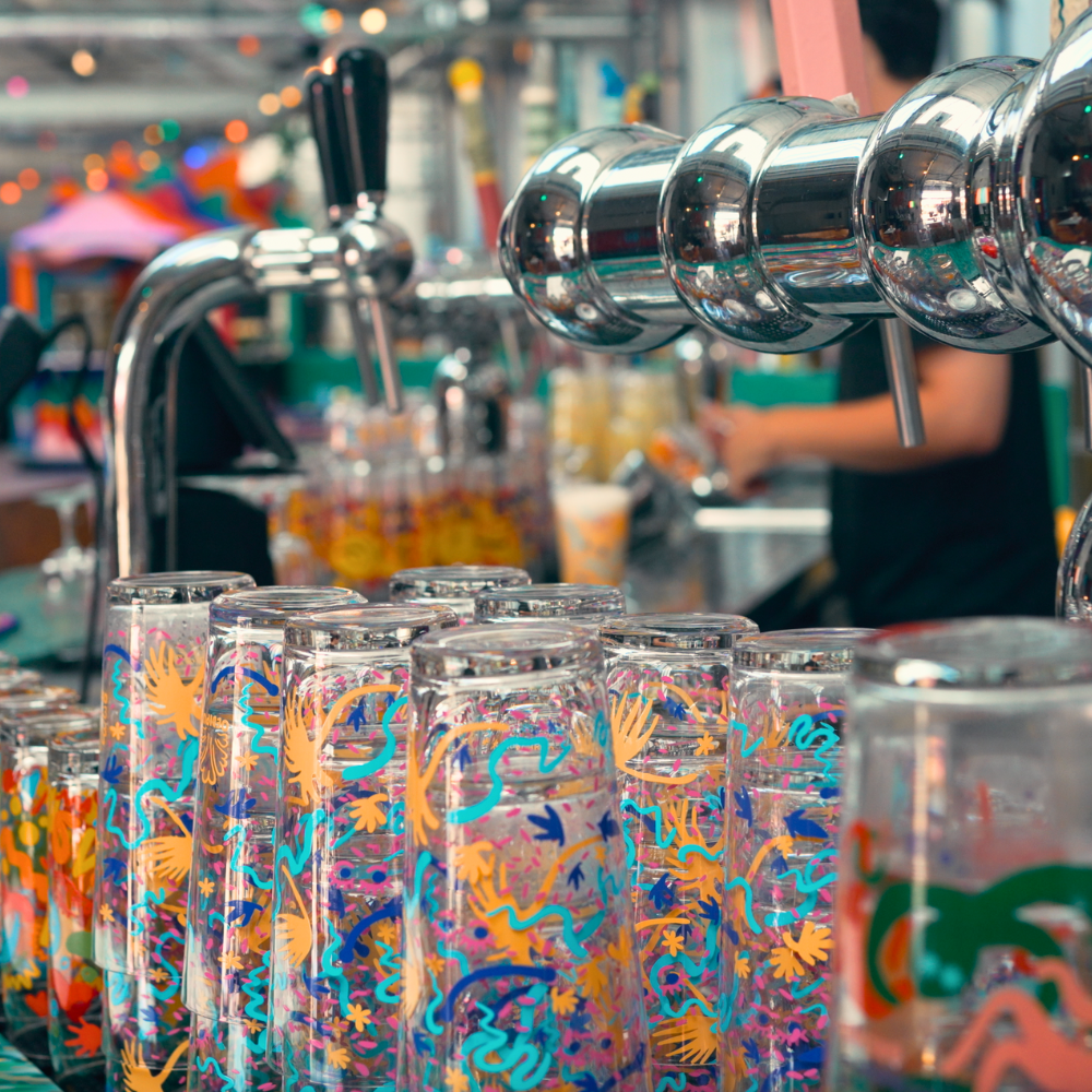 Oedipus Brewing taproom in Amsterdam, showcasing vibrant beer cans lined up at the bar.
