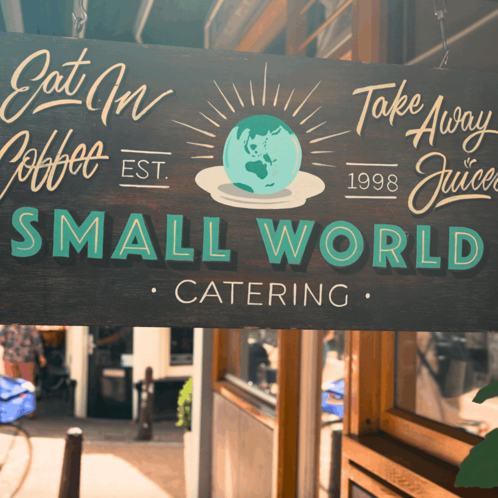 Sign for Small World Catering in Amsterdam, a café and catering spot known for hearty sandwiches and local flavor.