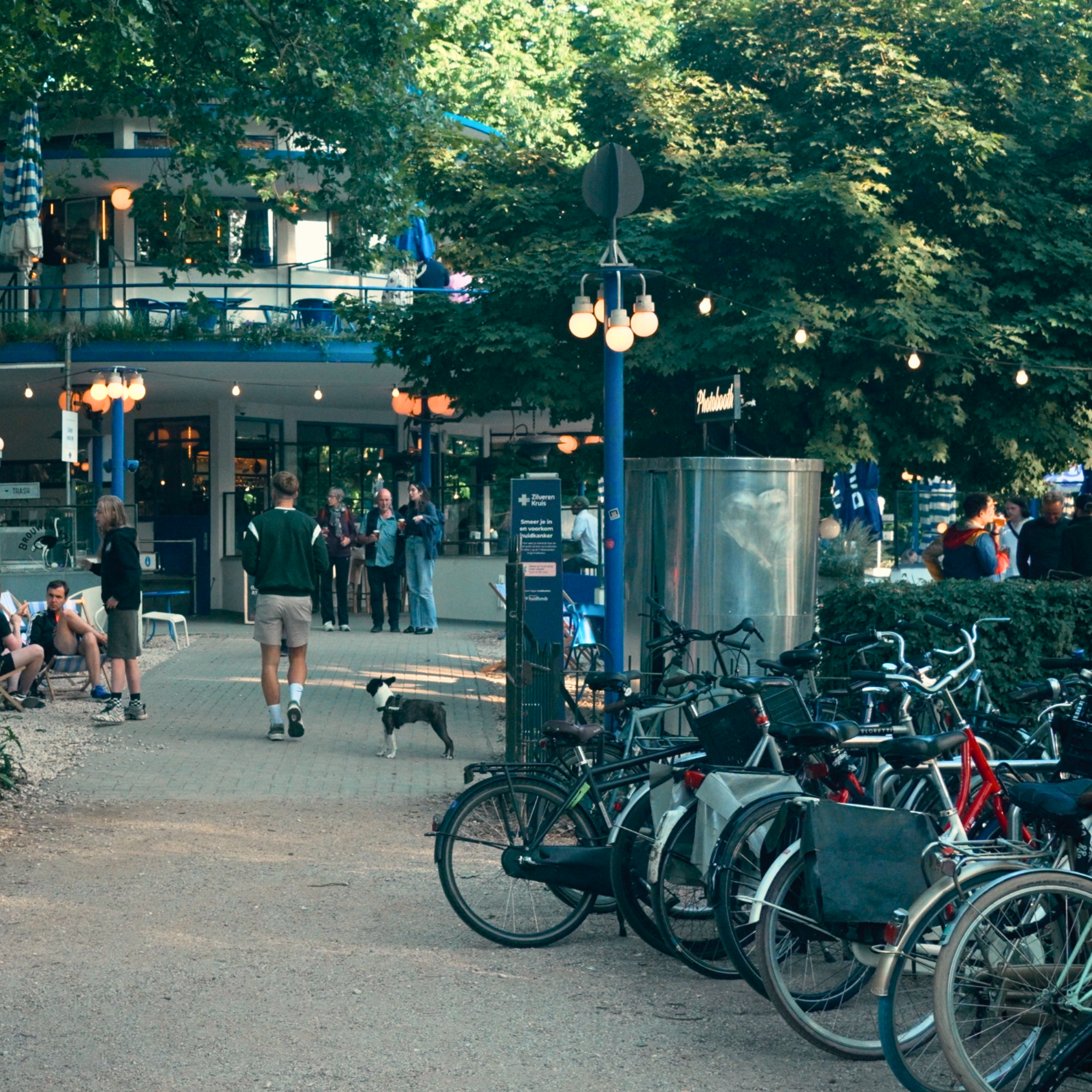 Taproom at ’t Blauwe Theehuis in Vondelpark, Amsterdam, with bicycles parked outside and people gathering for local beer.