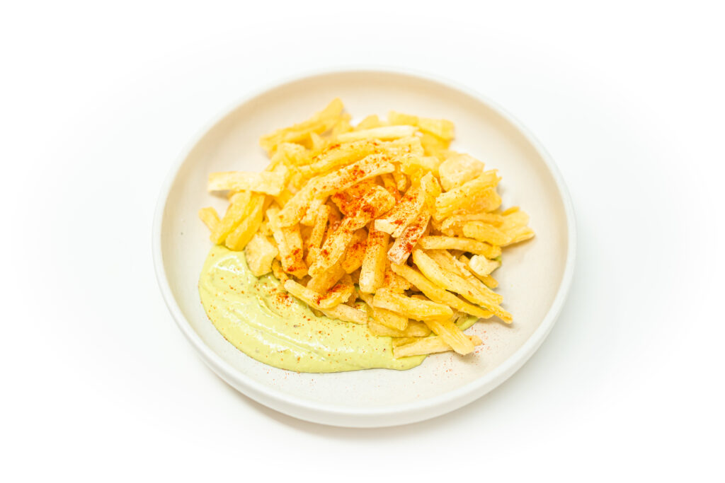 Golden crispy yuca fries served with creamy avocado aioli dip, a Latin American appetizer made from cassava root.