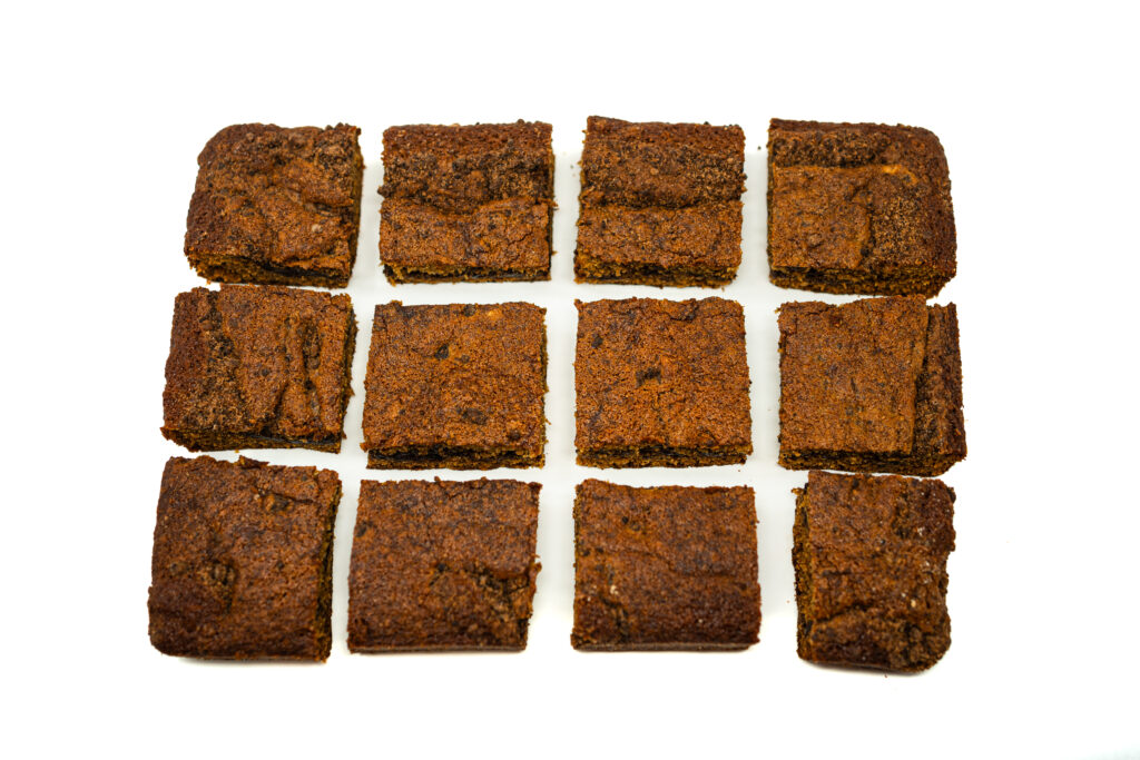 A close-up of a slice of espresso liqueur coffee cake featuring a distinct dark chocolate strata layer in the center against a white background.