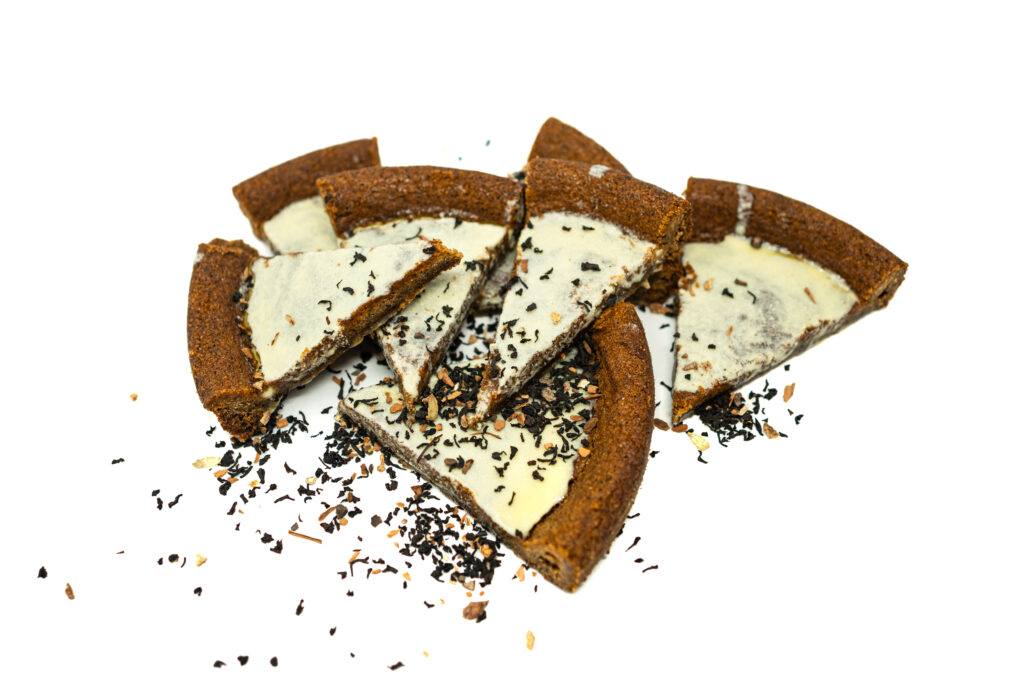 Close up of golden brown chai spice shortbread wedges dipped in white chocolate glaze and sprinkled with loose tea spices.