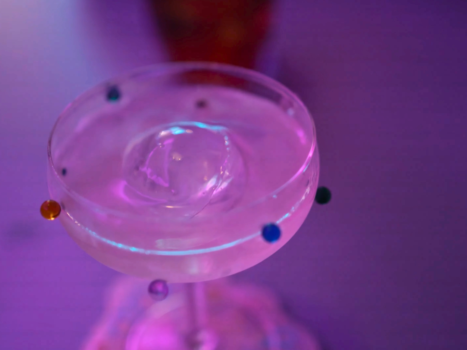 A clarified, minimalist cocktail garnished with geometric precision at Abstract Bar.