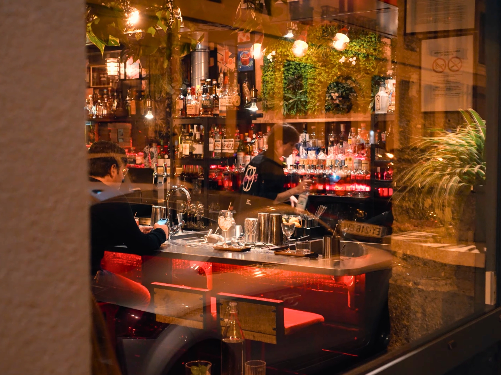 The moody, warmly lit bar area of L'Alchimiste in Lyon.