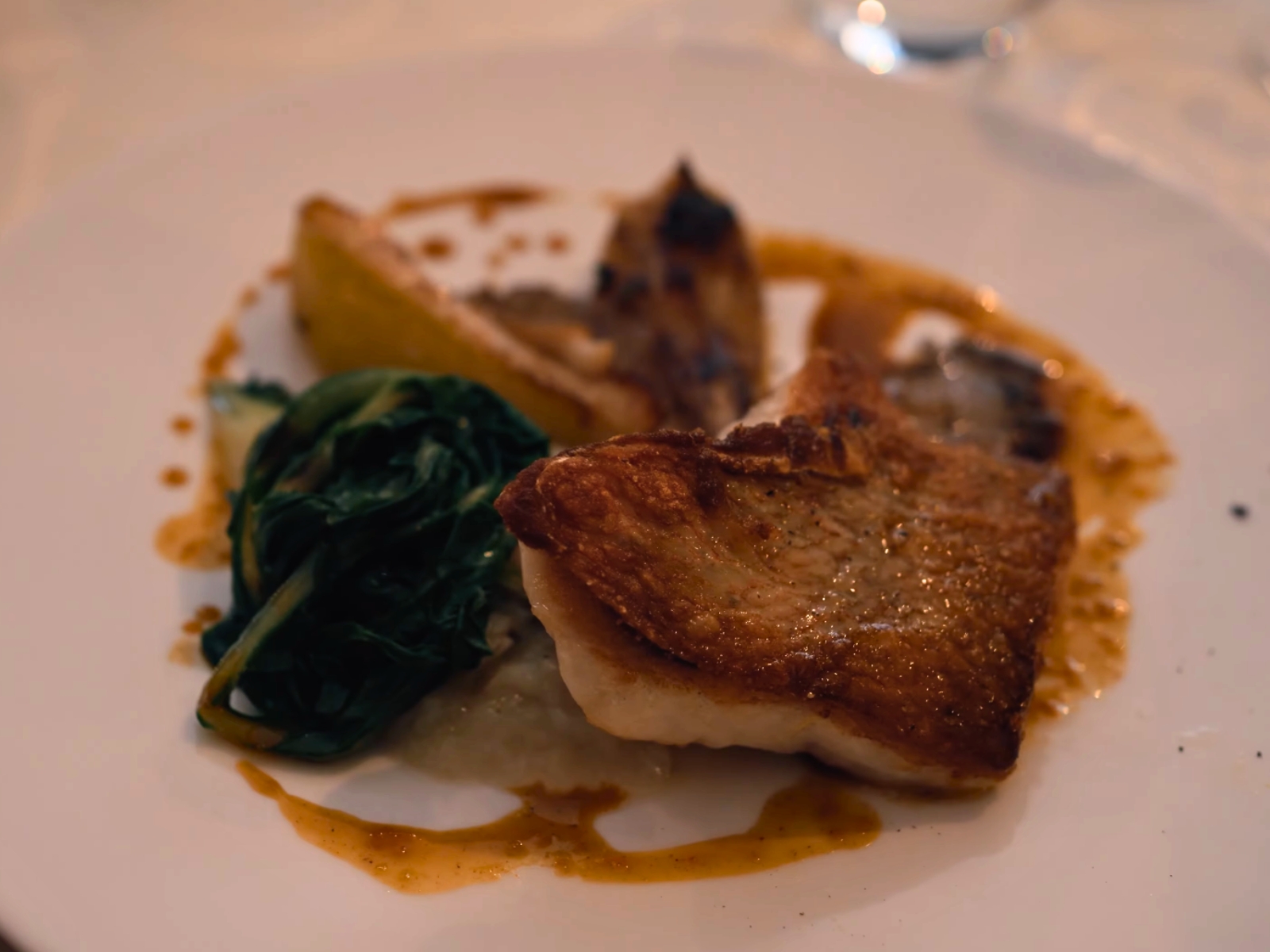 A beautifully seared piece of fish served with vibrant fresh greens at Le Mangevins.