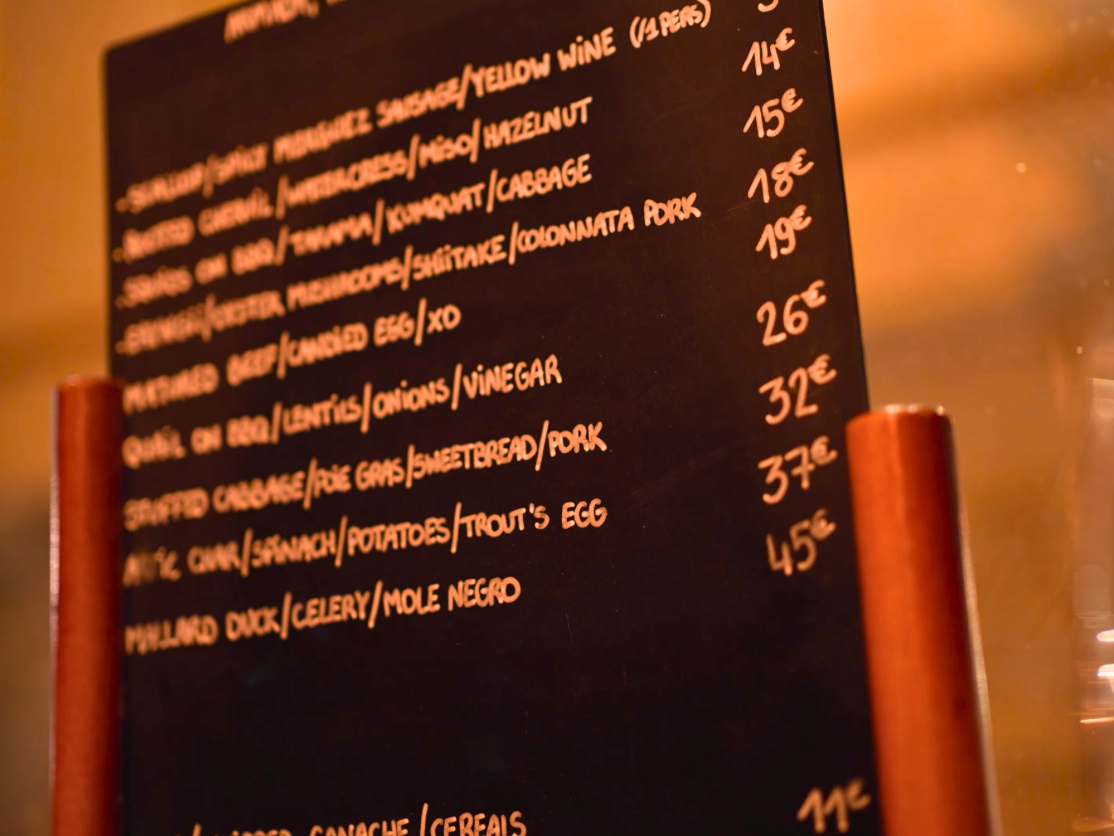 A handwritten chalkboard menu displaying hyper-seasonal dishes at Armada neo-bistro in Lyon.