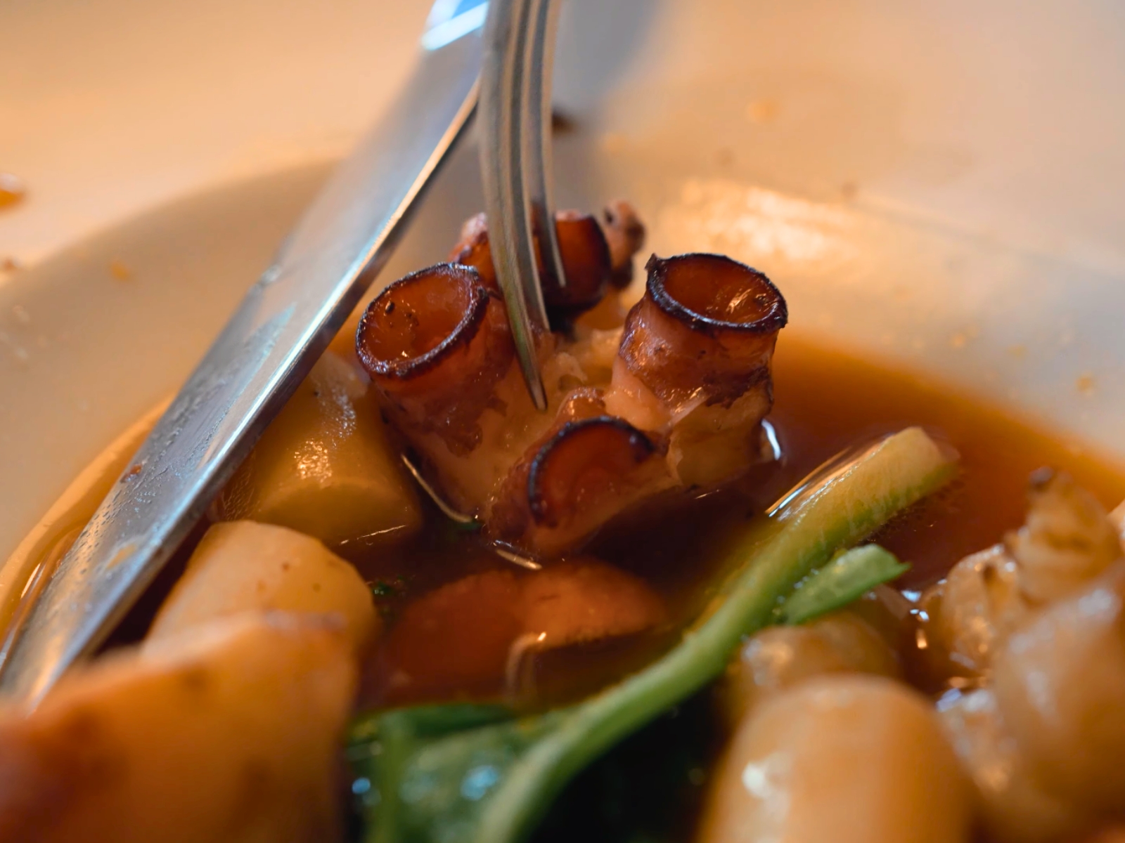 Close-up of a perfectly executed octopus and potato dish in savory broth at Takao Takano.