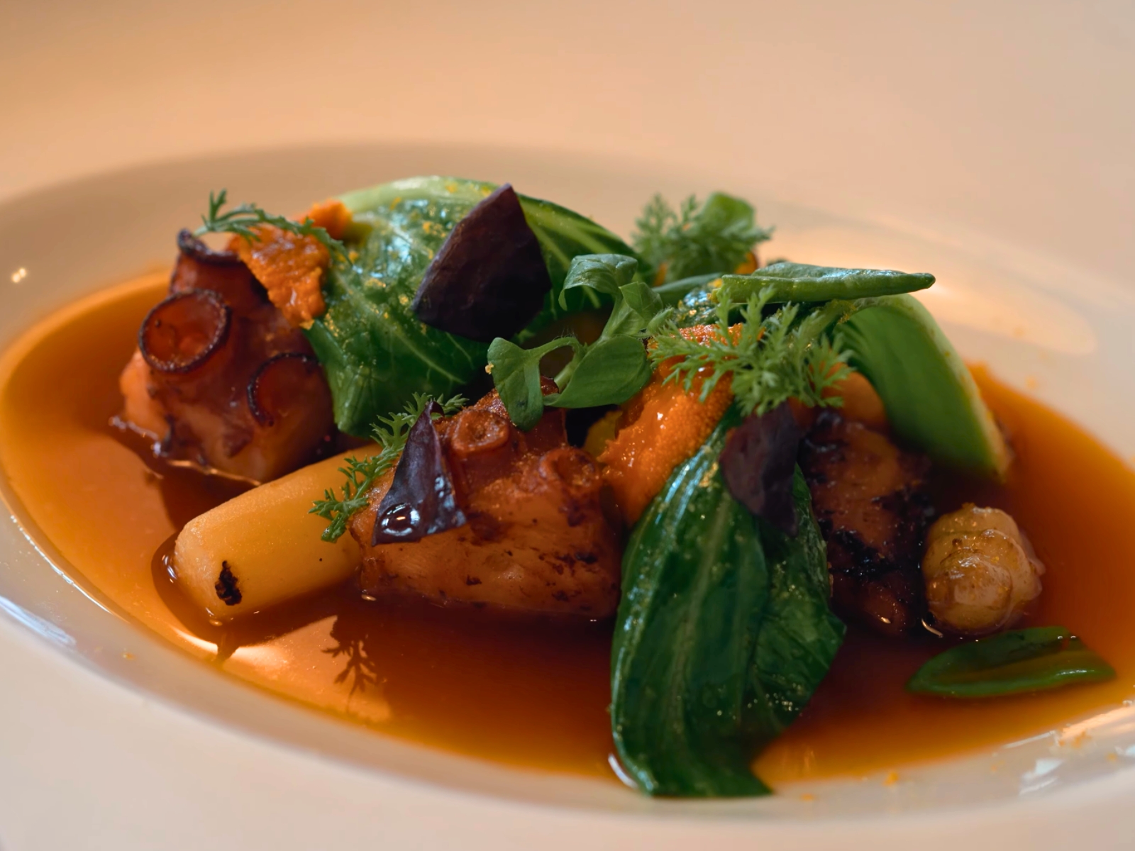 A delicate, two-Michelin-star octopus dish garnished with fresh greens at Takao Takano.