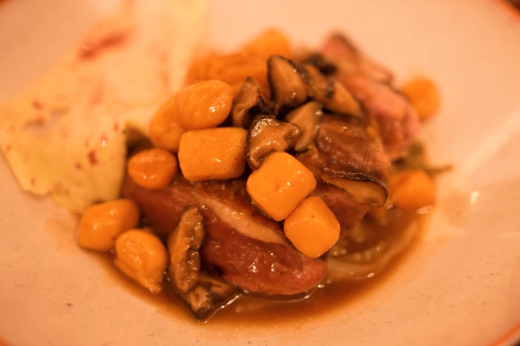 Close-up of a plated roasted duck and root vegetable dish at Juveniles in Paris.