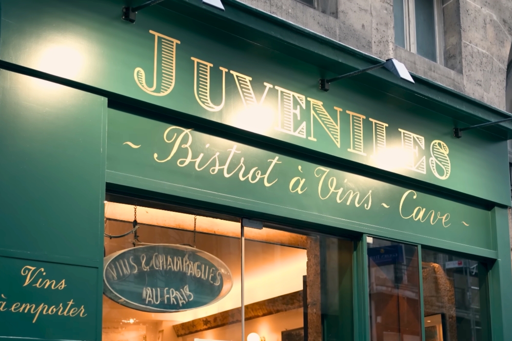 Exterior of Juveniles Bistrot à Vins in Paris featuring its classic green facade and signage.